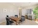 Home office with a wooden desk, chairs, and views from a large window at 5719 Christian Creek Ct, Las Vegas, NV 89149
