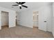 Bedroom featuring en-suite bathroom, walk-in closet, ceiling fan, and neutral carpet at 613 Kings Pl, Boulder City, NV 89005