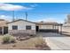 Charming single-story home featuring a brick facade and covered parking with desert landscaping in the front yard at 613 Kings Pl, Boulder City, NV 89005