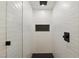 Modern shower featuring white tile, a shower niche, and black hardware at 613 Kings Pl, Boulder City, NV 89005