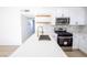 Contemporary kitchen boasting sleek white cabinets, stainless steel appliances, and open wood shelving at 6170 W University Ave, Las Vegas, NV 89103