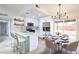 Updated kitchen with stainless steel appliances, white cabinets, and an island with seating, plus adjacent dining space at 6170 W University Ave, Las Vegas, NV 89103