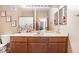 Well-lit bathroom with framed floral prints above toilet and vanity, large mirror, and floral shower curtain at 7163 S Durango Dr # 303, Las Vegas, NV 89113