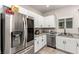Modern kitchen featuring stainless steel appliances, light granite countertops, and white cabinetry at 7457 Onyx Star St, North Las Vegas, NV 89084