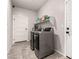 Well-lit laundry room with modern washer and dryer and overhead storage shelving at 7457 Onyx Star St, North Las Vegas, NV 89084