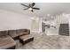 Open-concept living room with tile flooring, a modern couch, and seamlessly connected kitchen at 7457 Onyx Star St, North Las Vegas, NV 89084