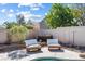 Backyard patio area with lounge chairs, surrounded by mature landscaping and a partial view of the pool at 9581 Ancala Hollow Ct, Las Vegas, NV 89148