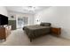 A carpeted primary bedroom with a ceiling fan, a bed, two dressers and a window with white shutters at 9581 Ancala Hollow Ct, Las Vegas, NV 89148
