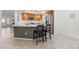 Open-concept kitchen with bar stool seating at kitchen island with wooden cabinets and stainless steel appliances at 9581 Ancala Hollow Ct, Las Vegas, NV 89148