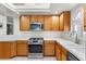 Well-lit kitchen featuring wooden cabinetry, tile countertops, stainless steel appliances and diamond pattern tile floors at 9581 Ancala Hollow Ct, Las Vegas, NV 89148