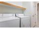 Laundry room featuring a tile floor, a shelf, and white washer and dryer units at 9581 Ancala Hollow Ct, Las Vegas, NV 89148