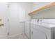 Clean laundry room featuring a tile floor, a shelf, and white washer and dryer units at 9581 Ancala Hollow Ct, Las Vegas, NV 89148