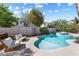 Inviting backyard pool and spa with patio chairs, mature landscaping, and a beautiful blue sky above at 9581 Ancala Hollow Ct, Las Vegas, NV 89148