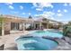 Backyard with a pool and attached jacuzzi, complete with mature landscaping and a covered patio area at 9581 Ancala Hollow Ct, Las Vegas, NV 89148