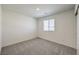 A carpeted bedroom featuring a window with horizontal blinds that filters natural light at 9926 Ullom Dr # 4, Las Vegas, NV 89141