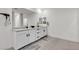 Bathroom featuring double sinks with white cabinets, gray rugs, modern fixtures, and a large mirror at 10122 Mystic Falls Dr, Las Vegas, NV 89141