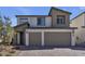 Two-story home with a modern design, neutral color palette, two-car garage, and low maintenance rock landscaping at 10122 Mystic Falls Dr, Las Vegas, NV 89141