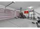 Garage with epoxy floors, weightlifting equipment, storage racks and multiple parked vehicles at 10122 Mystic Falls Dr, Las Vegas, NV 89141