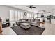 Open concept floor plan with modern decor, bright lighting, and a large gray sectional at 10122 Mystic Falls Dr, Las Vegas, NV 89141