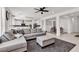 Open concept living room with gray sectional, neutral color palette, and modern decor at 10122 Mystic Falls Dr, Las Vegas, NV 89141