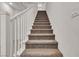 Staircase with carpeted steps, white railing and white walls leading to the upper level at 10122 Mystic Falls Dr, Las Vegas, NV 89141