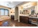 Spacious bathroom with wood-look tile, dual sink vanity and a separate tub under a window at 1013 Baronet Dr, Las Vegas, NV 89138