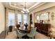 Elegant dining room features modern chandelier, ornate mirror, and stylish furnishings at 1013 Baronet Dr, Las Vegas, NV 89138