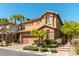 Two-story home with desert landscaping, tan stucco, brick driveway, palm trees and a two-car garage at 1013 Baronet Dr, Las Vegas, NV 89138