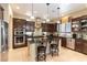 Stylish kitchen features dark wood cabinetry, stainless steel appliances, and a central island with seating at 1013 Baronet Dr, Las Vegas, NV 89138