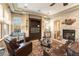 Inviting living room featuring a stone fireplace, custom built-ins, and ample natural light from large windows at 1013 Baronet Dr, Las Vegas, NV 89138