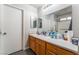 Bright bathroom featuring a single sink vanity with wood cabinets and a large mirror at 1017 Cliffbrook Hedge Ave, North Las Vegas, NV 89081