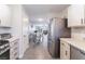 Well-lit kitchen showing stainless steel appliances, white cabinets, and access to the dining and living room at 1017 Cliffbrook Hedge Ave, North Las Vegas, NV 89081