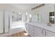 Bright bathroom with a soaking tub and double sink vanity with makeup lighting at 1021 Gary Carmena Ave, North Las Vegas, NV 89081