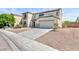 Inviting two-story home with a neutral stucco facade, attached garage and minimal landscaping at 1021 Gary Carmena Ave, North Las Vegas, NV 89081