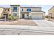 Inviting two-story home with a neutral stucco facade, attached garage and minimal landscaping at 1021 Gary Carmena Ave, North Las Vegas, NV 89081