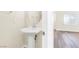 Powder room with pedestal sink, modern faucet, round mirror, and beautiful plank flooring at 10510 Mojave Ridge Ct, Las Vegas, NV 89183