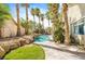 Landscaped backyard featuring a charming pool, stone pathway and mature palm trees at 124 Beach Oak Ave, Henderson, NV 89002