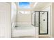 Bathroom featuring a bathtub and glass-enclosed shower with updated tile at 124 Beach Oak Ave, Henderson, NV 89002