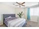 Bedroom features a large bed, a window with curtains, a ceiling fan, and carpeted floors at 124 Beach Oak Ave, Henderson, NV 89002