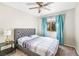 Bedroom features a large bed, a window with curtains, a ceiling fan, and carpeted floors at 124 Beach Oak Ave, Henderson, NV 89002