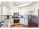 Bright kitchen with white cabinets, stainless steel appliances, granite countertops, and eye-catching backsplash at 124 Beach Oak Ave, Henderson, NV 89002