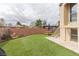 Spacious back yard featuring lush green turf, complemented by a brick wall and staircase access to upper level at 1312 Georgia Ave # D, Boulder City, NV 89005
