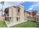 View of the home's architecture with a stucco exterior, covered patio, and artificial turf in the backyard at 1312 Georgia Ave # D, Boulder City, NV 89005