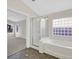 Bathroom with tile floor, bathtub with glass door and a window letting in plenty of natural light at 1326 Winter Solstice Ave, Henderson, NV 89014