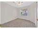 Bright bedroom featuring neutral walls, plush carpet, a ceiling fan, and a large window with a street view at 1326 Winter Solstice Ave, Henderson, NV 89014
