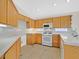 Well-lit kitchen with ample counter space, white appliances, and light wood cabinets at 1326 Winter Solstice Ave, Henderson, NV 89014