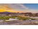 Expansive aerial view showcases the community's picturesque golf course, lake, and stunning mountain backdrop at sunset at 21 Via Visione # 101, Henderson, NV 89011