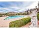 Inviting community pool surrounded by manicured landscaping, lounge chairs, and elegant statues, offering a relaxing retreat at 21 Via Visione # 101, Henderson, NV 89011