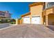 Attached two-car garage with a paved driveway and manicured landscaping at 21 Via Visione # 101, Henderson, NV 89011