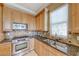 Gourmet kitchen with stainless steel oven, granite counters, and wood cabinetry at 21 Via Visione # 101, Henderson, NV 89011